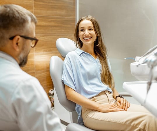 Patient smiling while talking to dentist in treatment chair