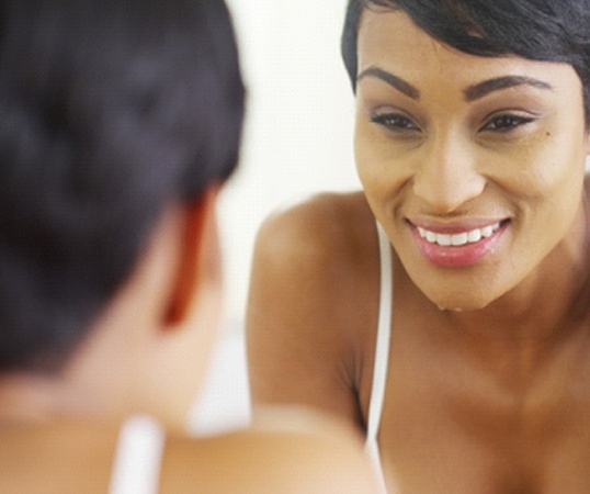Woman looking in mirror at teeth