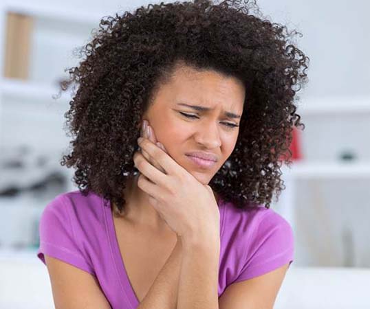 Woman with a toothache in Mesquite holding her cheek