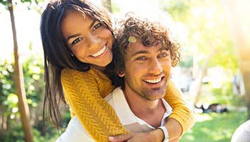 Young couple smiling and hugging outside