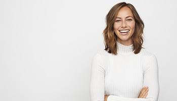 woman smiling with dental implants in Mesquite with a white background