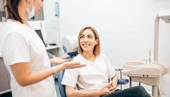 Happy dental patient learning about dental implant treatment