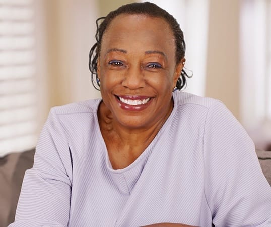 Smiling older woman with dental implants in Mesquite 