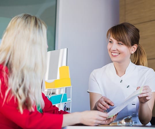 Dental team member showing patient insurance forms