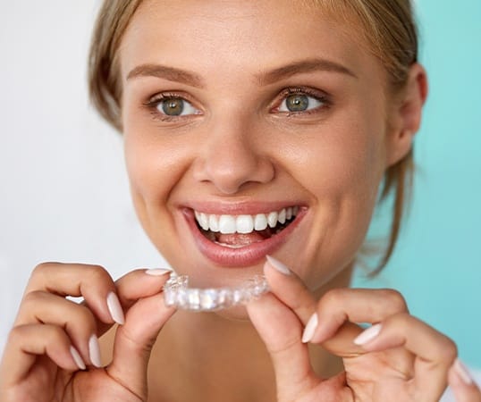 Woman placing Invisalign clear braces tray