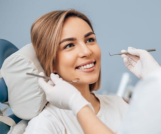 Woman receiving preventive dentistry checkup and teeth cleaning