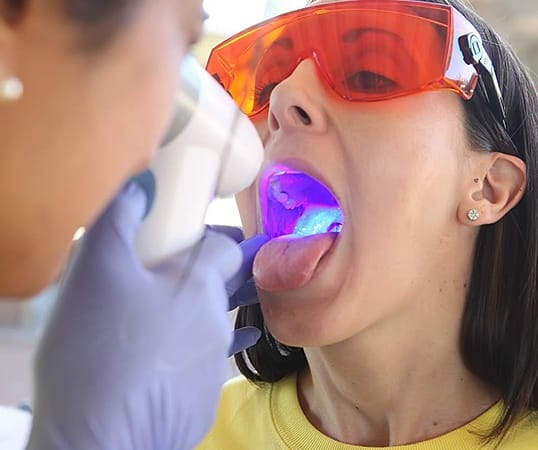 Dentist performing oral cancer screening