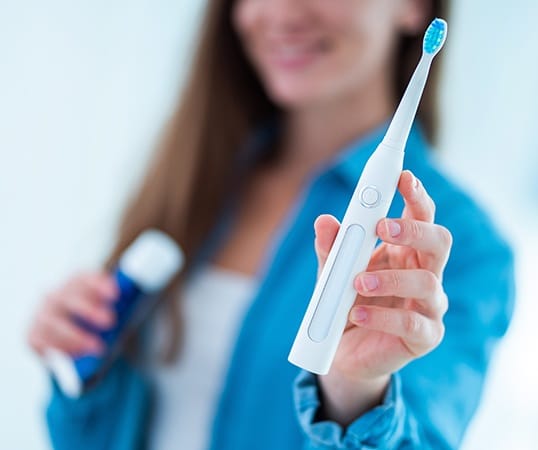 Woman holding an electric toothbrush