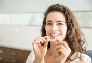 Woman placing Invisalign tray