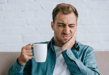 Man in need of emergency dentistry holding jaw