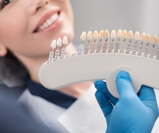 Dentist showing patients shades of veneers