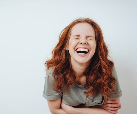 Young woman laughing with bright, white teeth