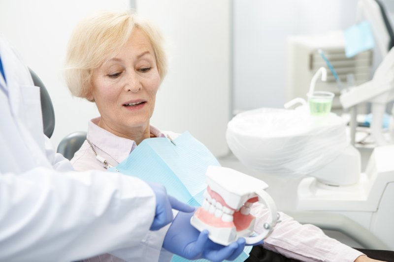 Senior patient looking at a pair of dentures