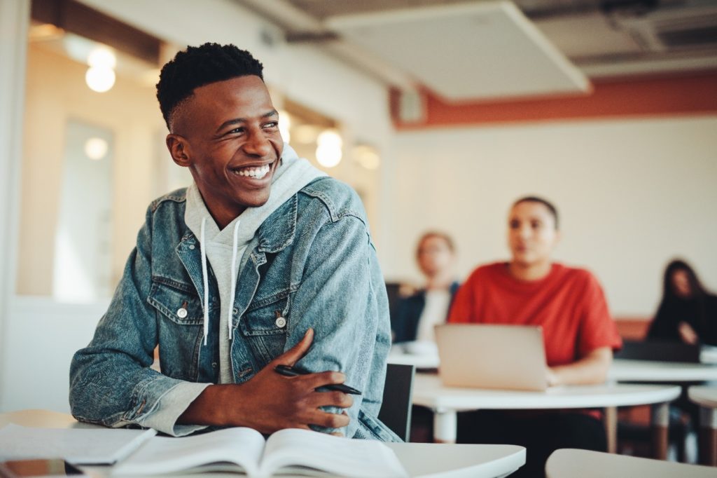 Teen boy smiling while sitting in classroom