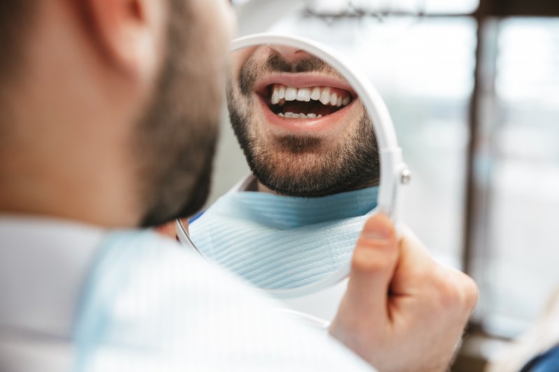 Man smiling at his new dental implant